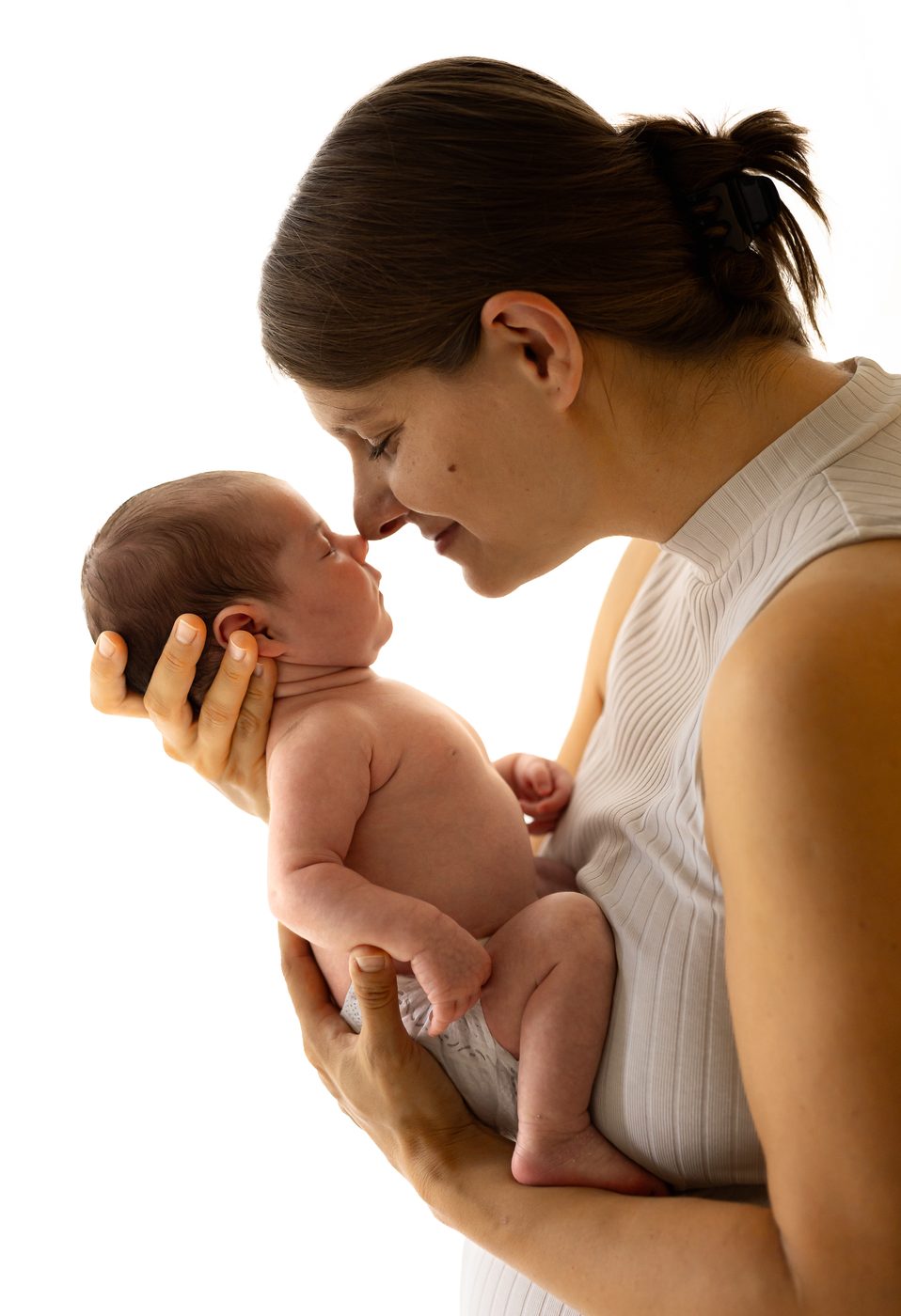 Eine Mama ber&uuml;hrt ihr Neugeborenes z&auml;rtlich Nase an Nase