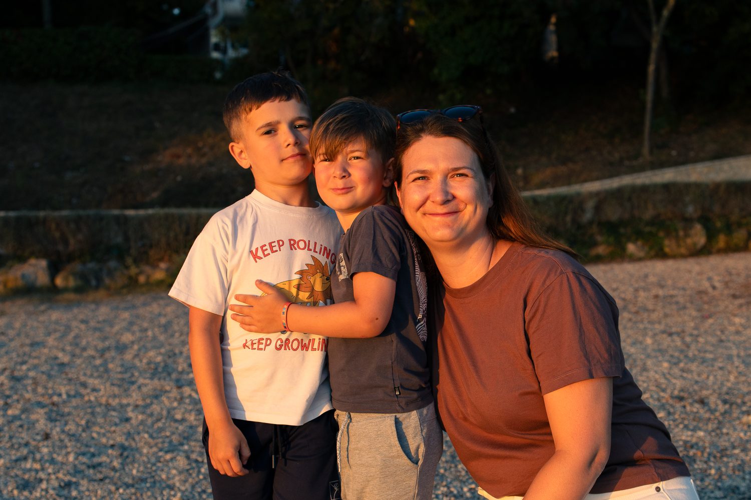 Kerstin mit ihren zwei S&ouml;hnen im Abendlicht, die drei kuscheln sich aneinander